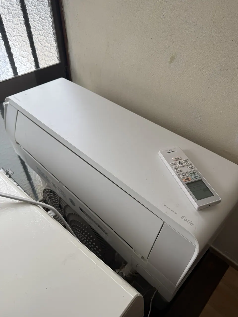 取り外したエアコン室内機とリモコン